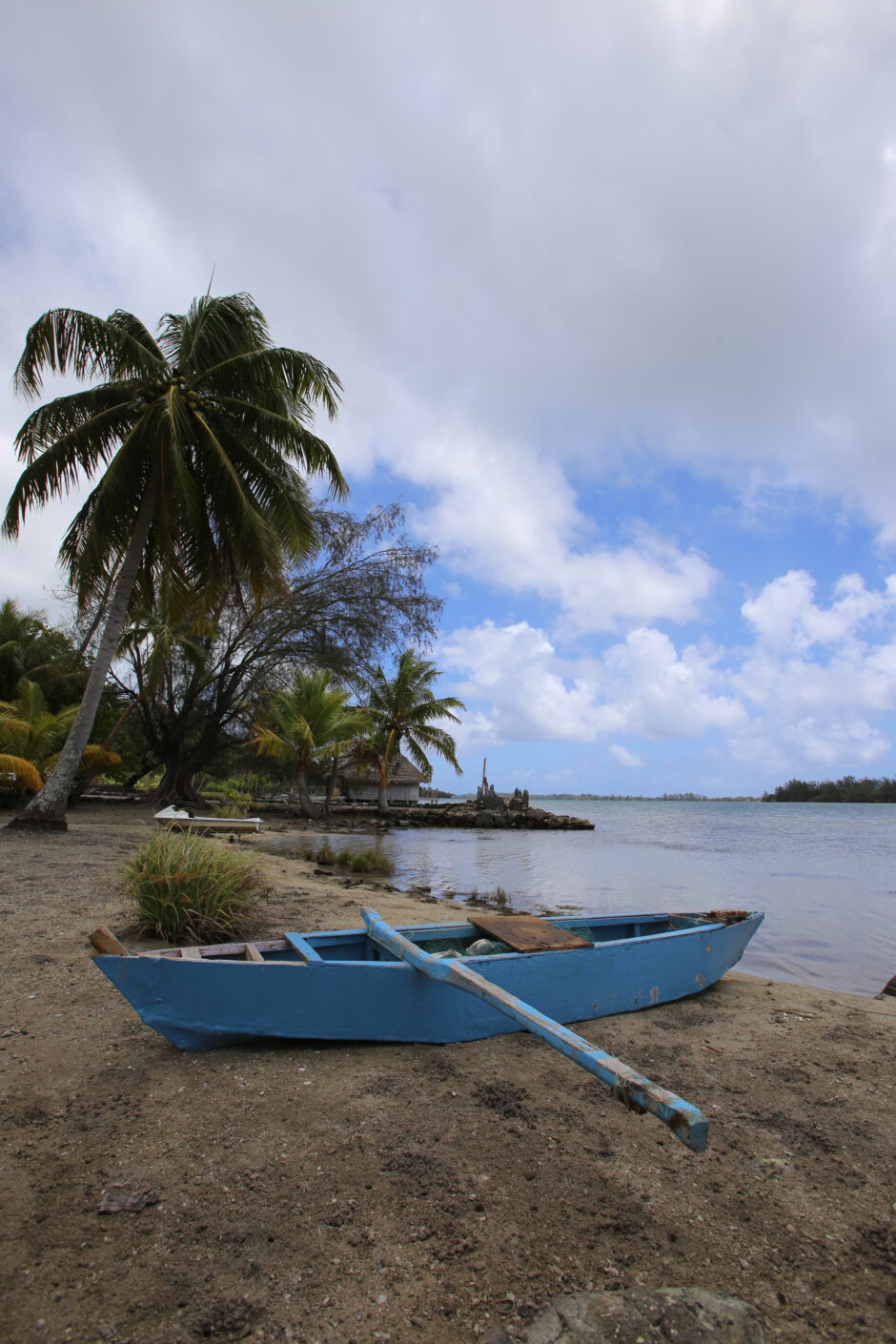 a rowboat on the shore in Huahine, French Polynesia by the water at the marae